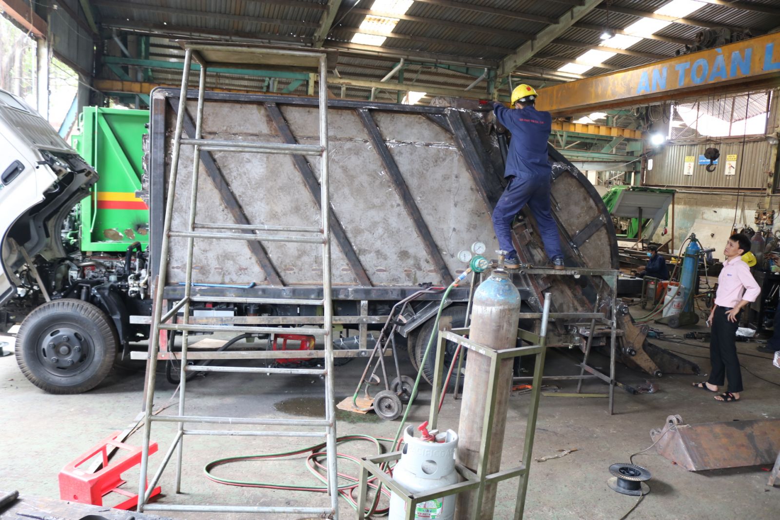 công nhân đang đóng thùng xe cuốn ép rác 6 khối tại xưởng đóng thùng xe ép rác Hino Đại Phát Tín